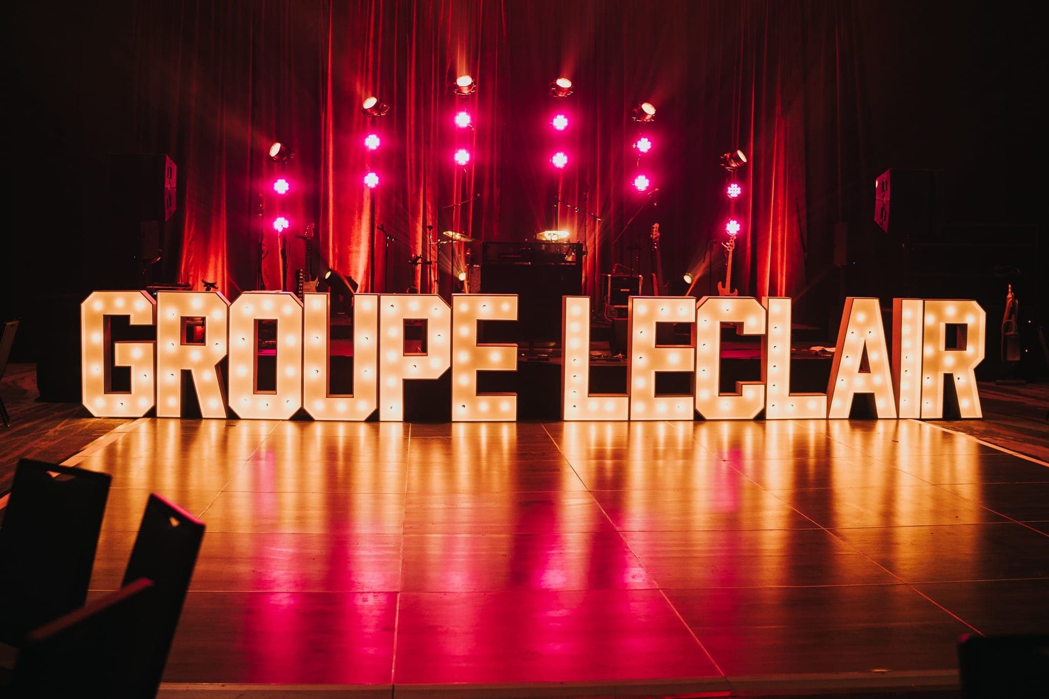 Lettres lumineuses géantes sur une piste de danse, scène en lavage rouge